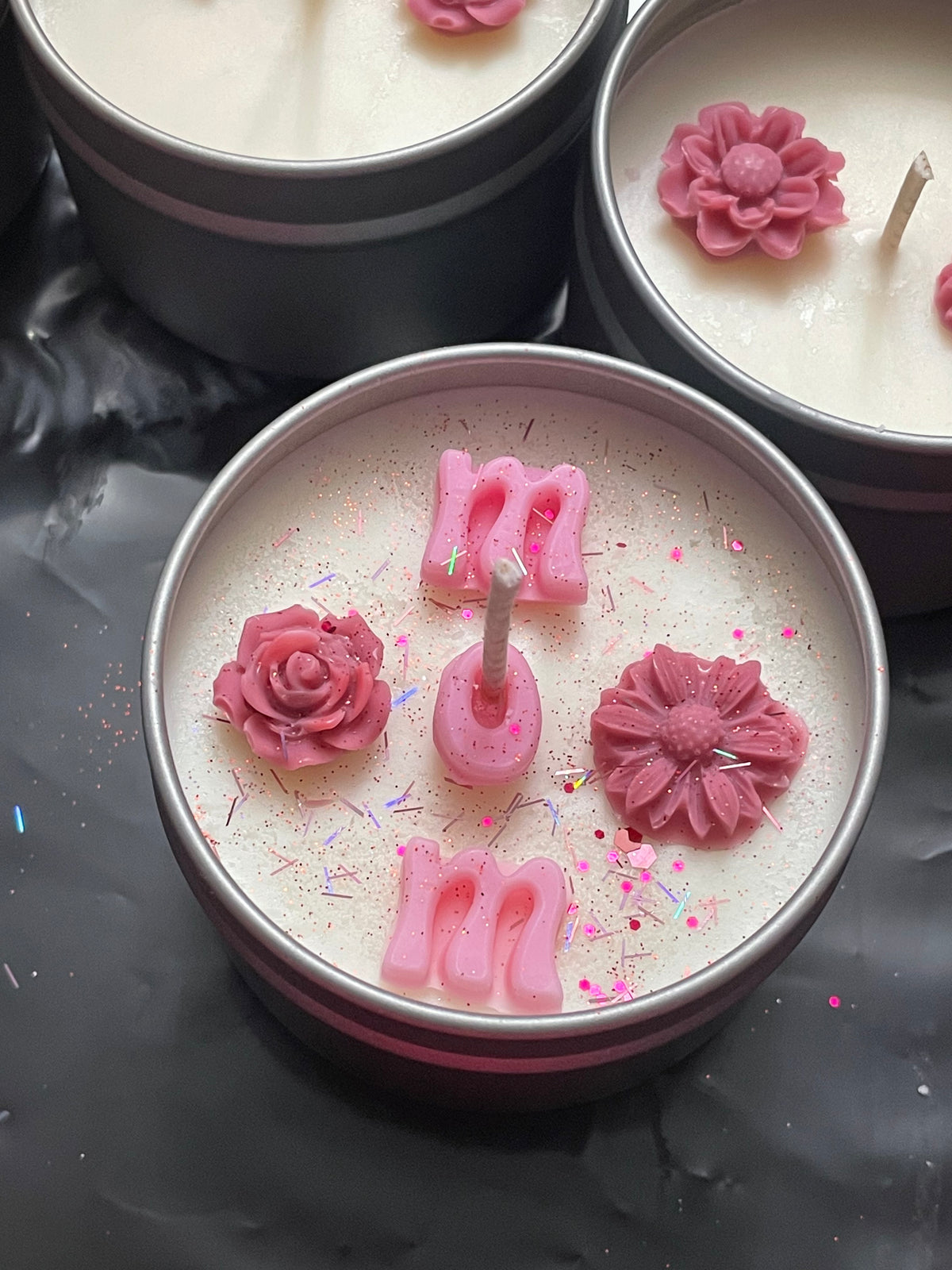 Candle with pink floral designs on a white surface